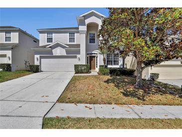 Charming two-story home with well-maintained landscaping, two-car garage and inviting front entrance at 7761 Tosteth St, Kissimmee, FL 34747