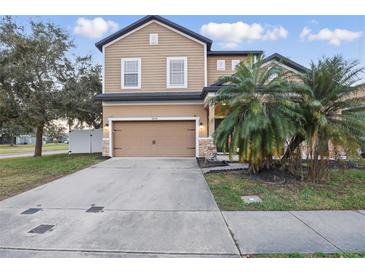 Charming two-story home featuring a tan exterior, a two-car garage, and a well-manicured front lawn at 1894 Valley Forge Dr, St Cloud, FL 34769