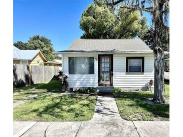 Charming single-story home with white siding and a well-maintained front yard with walkway at 1013 Illinois Ave, St Cloud, FL 34769