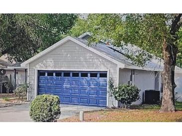 Charming single-story home featuring a striking blue garage door and a well-maintained lawn at 1021 Royal Oaks Dr, Apopka, FL 32703