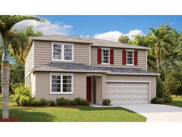 Two-story home boasts a manicured lawn, neutral siding, red shutters, and attached two car garage at 1127 Olivine Ave, Dundee, FL 33838