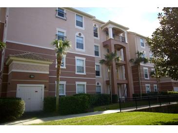 Beautiful condo building featuring stucco siding, palm trees and a private balcony on multiple floors at 1357 Venezia Ct # 302, Davenport, FL 33896