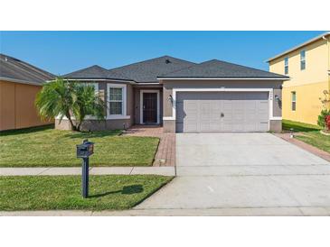 Charming single Gathering home with well maintained lawn, a grey roof, and an attached two-car garage at 2040 Patriot Way, St Cloud, FL 34769