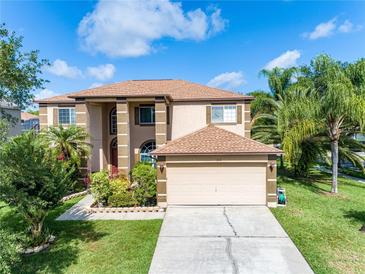 Charming two-story home featuring a well-manicured lawn, complemented by lush landscaping and a two-car garage at 214 Farrington Ln, Kissimmee, FL 34744