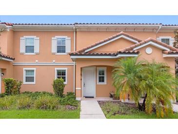 Charming two-story townhouse featuring a red tile roof and a well-maintained landscaped front yard at 2634 Corvette Ln, Kissimmee, FL 34746