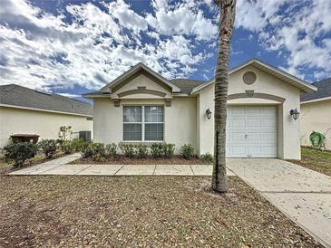 Inviting single-story home featuring a well-manicured lawn and attached one car garage at 2993 Kokomo Loop, Haines City, FL 33844