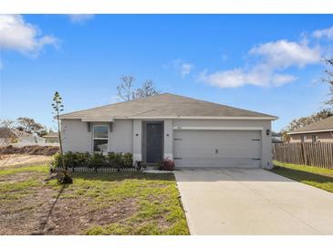 Charming single-story home featuring a two-car garage, freshly painted exterior, and a well-manicured front lawn at 408 Danube Dr, Poinciana, FL 34759