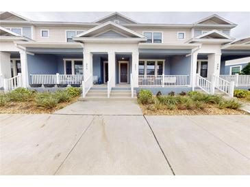 Charming townhome featuring a covered front porch with white railings and neatly landscaped surroundings at 452 Diamond Dove Cv, Winter Springs, FL 32708