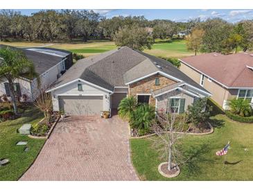 Beautiful single Gathering home featuring a stone facade, well-manicured lawn, and golf course views at 538 Via Vitale Ct, Kissimmee, FL 34759