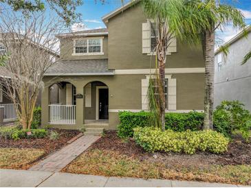 Two-story home featuring lush landscaping, beige shutters and a brick walkway at 6441 Point Hancock Dr, Winter Garden, FL 34787