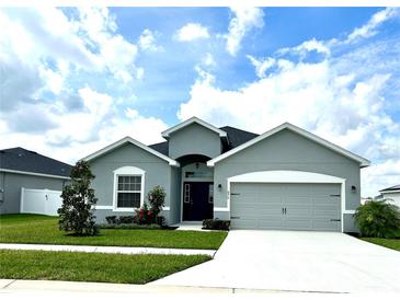 Charming one-story home with a well-manicured lawn and a two-car garage at 870 Galloway St, Lake Alfred, FL 33850