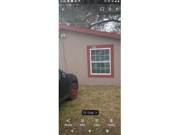 Exterior daytime view of a house with a red trim window and house number above at 888 Berkley Rd, Auburndale, FL 33823