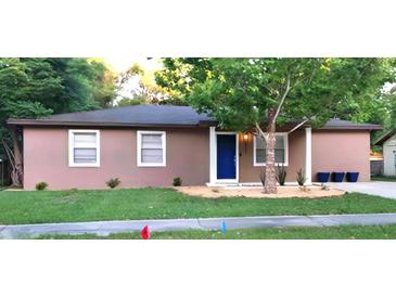 Charming single-story home with a well-manicured front lawn and a welcoming blue front door at 911 Kerry Blvd, Winter Haven, FL 33880