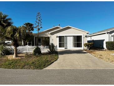 Charming single-story home featuring well-maintained landscaping, a paved driveway, and a screened garage at 9319 Se 173Rd Hyacinth St, The Villages, FL 32162