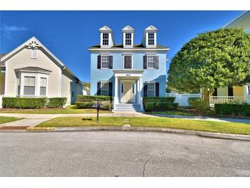 Charming blue two-story home with black shutters and a well-manicured front yard at 1111 Oscar Sq, Celebration, FL 34747