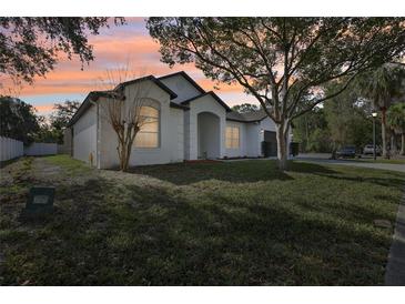 Beautiful single-story home with a manicured lawn and mature trees in a serene suburban setting at 411 Boxwood Dr, Davenport, FL 33837