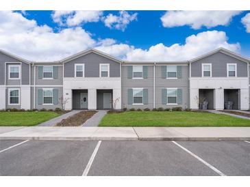 Gray townhome exteriors feature manicured lawns, sidewalks, and convenient parking at 4138 Lana Ave, Davenport, FL 33897