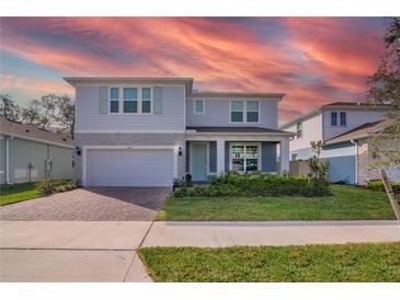 Charming two-story home boasts a brick-paved driveway, attached garage, and beautifully landscaped front yard at 3987 Meandering Bay Dr, Apopka, FL 32712