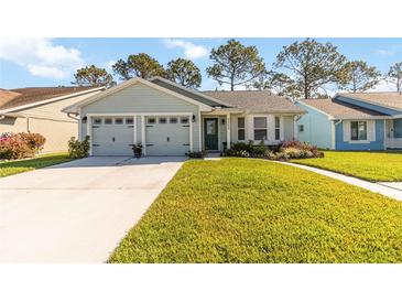 Charming single-story home with attached two-car garage and well-manicured lawn at 9559 Dubois Blvd, Orlando, FL 32825