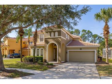 Charming two-story home with tile roof, arched entry, and well-manicured landscaping at 113 Tiger Lily Ct, Davenport, FL 33837