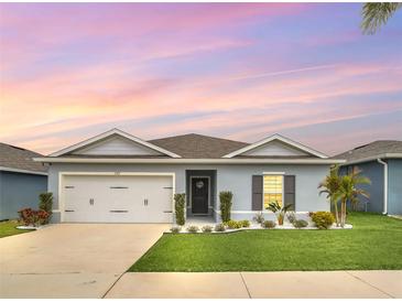 Charming single-story home with well-manicured lawn, lovely landscaping, and a two-car garage at 1185 Catskill Dr, Haines City, FL 33844