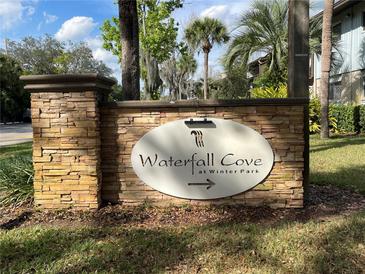 Stone sign for Waterfall Cove at Winter Park with tropical landscaping in the background at 1695 Lee Rd # E103, Winter Park, FL 32789