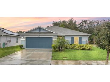 Charming single-story home featuring a well-maintained lawn, a two-car garage, and attractive landscaping at 1877 River Crest Ave, St Cloud, FL 34771