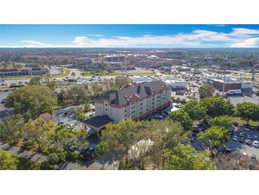 An aerial view shows the property with surrounding businesses and roads in a vibrant neighborhood at 3000 Maingate Ln # 205, Kissimmee, FL 34747