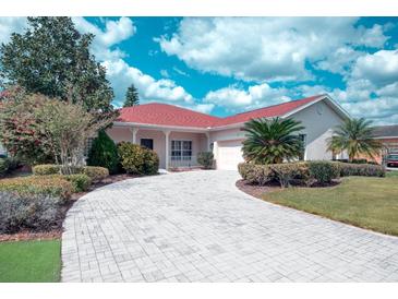 Charming single-story home featuring a well-manicured lawn, paver driveway, and inviting landscaping at 318 Rock Springs Dr, Poinciana, FL 34759