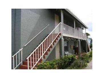 The exterior features stairs with white railings, and a covered porch at 717 Michigan Ct # 2, St Cloud, FL 34769