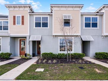 Charming townhouse featuring a modern design with complementary colored stucco and siding, landscaped front yard, and inviting entries at 1800 Tropical Palms Cir, Kissimmee, FL 34747