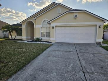 Charming one-story home featuring a manicured front yard and attached two-car garage at 231 Old Mill Cir, Kissimmee, FL 34746