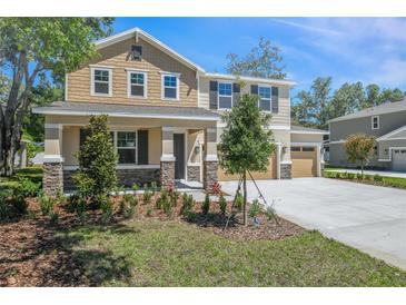 Charming two-story home featuring mixed siding, stone accents, a well-manicured lawn, and a two-car garage at 3757 Deer Ridge Dr, Mount Dora, FL 32757