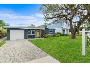 Charming single-story home with a well-manicured lawn, stone accents, and a paved driveway at 4217 Park Lake St, Orlando, FL 32803