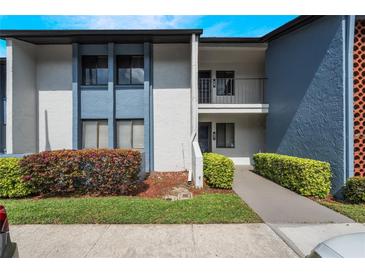 Inviting condo exterior with a blue and white facade, manicured bushes, and well-maintained walkway at 6 Escondido Cir # 58, Altamonte Springs, FL 32701