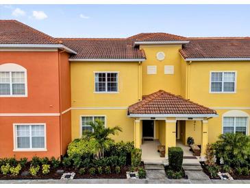 Colorful townhome featuring a red tile roof and inviting front entrance at 8971 Majesty Palm Rd, Kissimmee, FL 34747