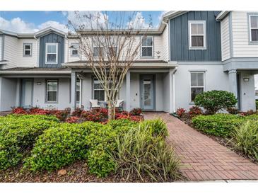 Charming two-story townhome with a welcoming front porch and well-maintained landscaping at 10414 Folly Beach Rd, Orlando, FL 32827
