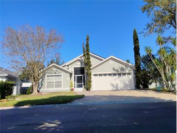 Charming single Gathering home featuring a two-car garage, well-manicured lawn, and mature landscaping at 250 Sir Phillips Dr, Davenport, FL 33837