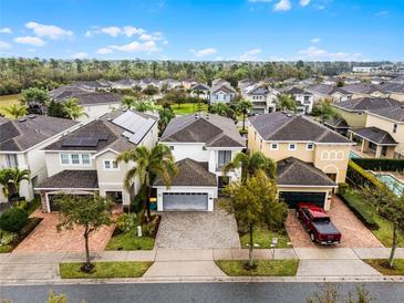 An aerial view of homes with manicured lawns, tree lined streets, and solar panels in a desirable neighborhood at 301 Pendant Ct, Kissimmee, FL 34747