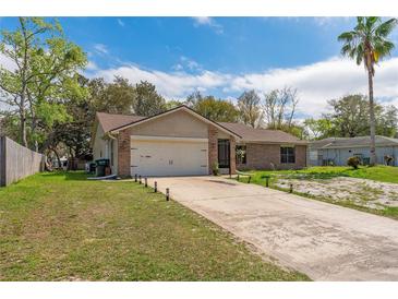 Charming single-story brick home featuring an attached two-car garage and well-maintained front yard at 3189 Saint James Ave, Deltona, FL 32738