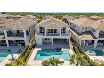 Stunning backyard with a sparkling pool, spa, and covered patio, perfect for outdoor entertaining at 7921 Jacks Club Dr, Kissimmee, FL 34747