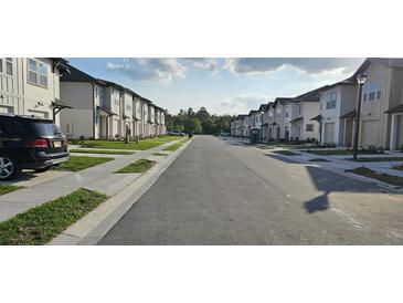 Community street view showcasing modern townhomes and a well maintained neighborhood at 803 Longboat Dr, Davenport, FL 33896