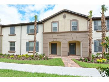 Charming townhome featuring a neutral palette, shutters, manicured lawn, and walkway at 8908 Adriatico Ln, Kissimmee, FL 34747