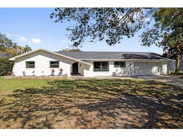 Charming single-story home featuring a well-manicured front yard and a two-car garage at 621 Avocado St, St Cloud, FL 34769