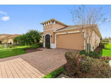 Beautiful home showcasing a brick paver driveway, a two-car garage and landscaped flower beds at 1264 Bonita Canyon Dr, Kissimmee, FL 34759