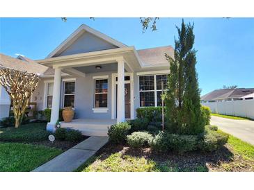 Charming single-story home with a welcoming front porch and well-manicured landscaping at 14620 Golden Rain Tree Blvd, Orlando, FL 32828