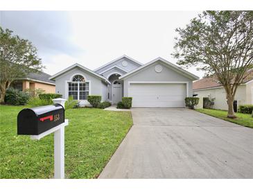 Charming single-story home with a well-manicured lawn, two-car garage, and welcoming front entrance at 153 Laurel Ridge Pass, Davenport, FL 33897