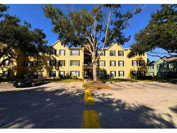 Condo building exterior with parking and trees on a sunny day at 2019 Dixie Belle Dr # 2019L, Orlando, FL 32812