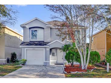 Charming two-story home with a well-maintained lawn and mature trees at 2450 Parsons Pond Cir, Kissimmee, FL 34743