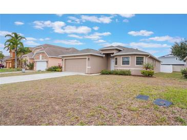 Charming single-story home featuring tan siding, well-maintained lawn and a two car attached garage at 251 Tower View W Dr, Haines City, FL 33844